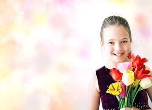 Mädchen bekommt Blumen zur Jugendweihe 2024