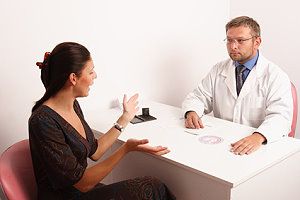 Eine Frau im Gespräch mit ihrem Frauenarzt über das Thema Scheinschwangerschaft