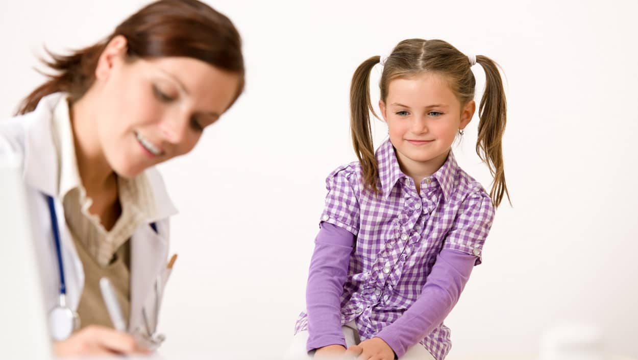 Ärztin unterhält sich mit kleinem Mädchen bei der U9 Untersuchung