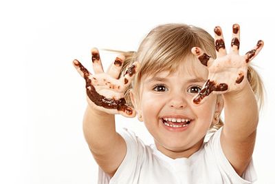 Mädchen hat geschmolzene Schokolade an den Händen