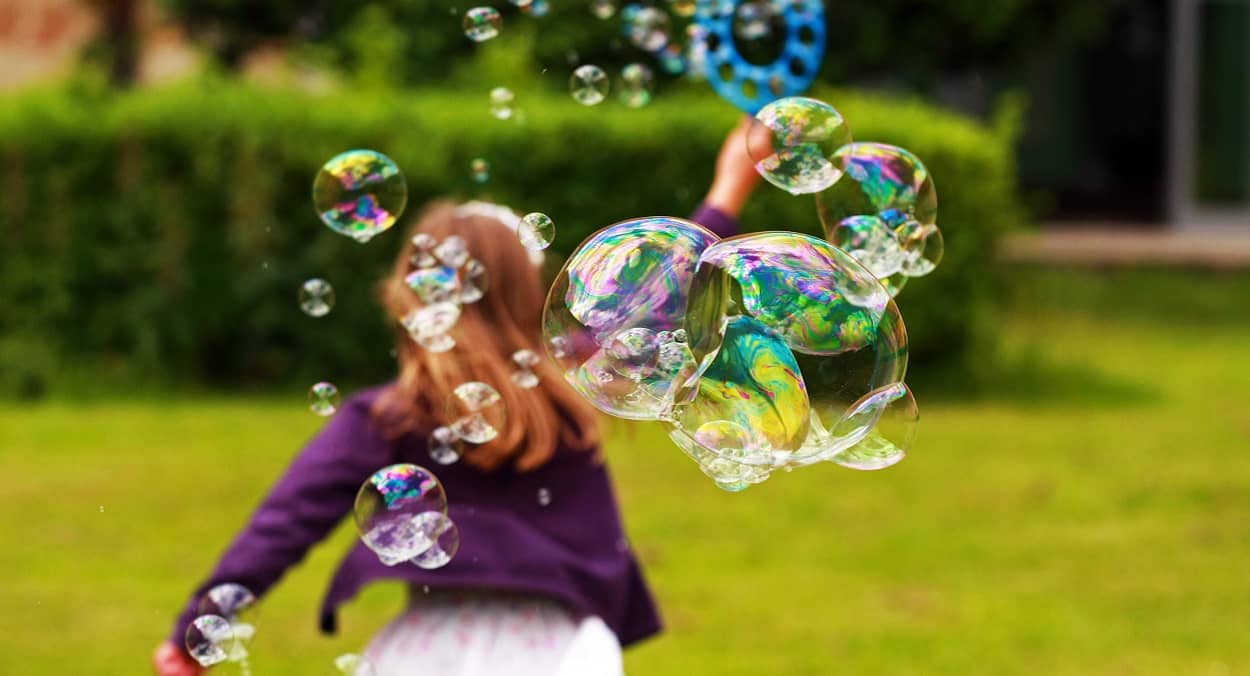 Mädchen freut sich über Seifenblasen und eine glückliche Kindheit