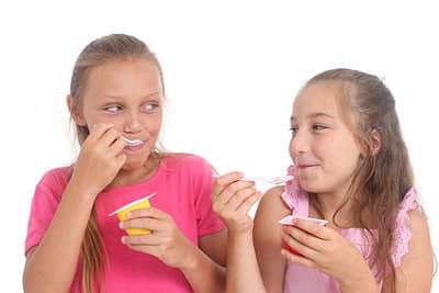 Zwei Mädchen essen Joghurt