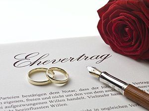 Ein Ehevertrag, eine Rose und Eheringe