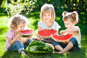 Kinder essen Melone bei einer Sommerparty