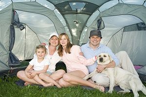 Eine Familie sitzt vor ihrem Zelt