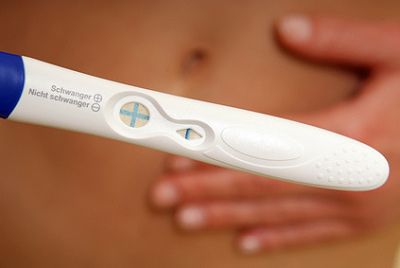 Eine Frau mit Schwangerschaftstest