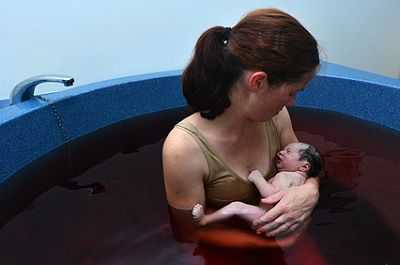 Mutter mit Neugeborenem im Wasser