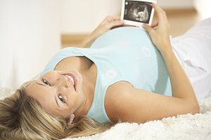 Eine Schwangere mit einem Ultraschallbild ihres Babys