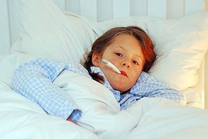 Mädchen liegt mit Fieber im Bett