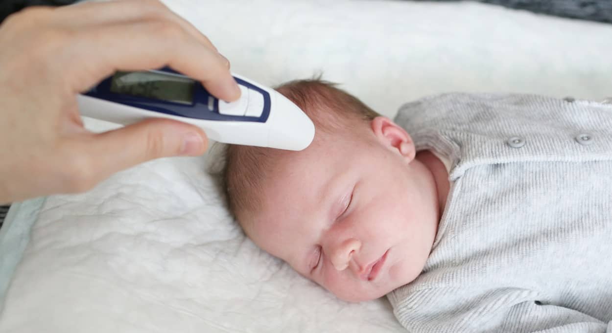 Fiebermessen beim Baby an der Schläfe