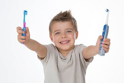 Junge mit zwei Zahnbürsten