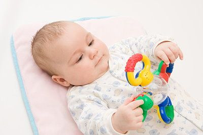 Ein Baby spielt mit einer Rassel