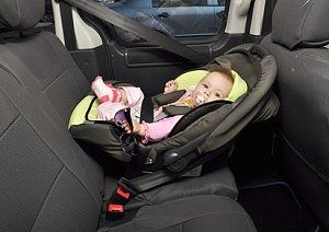 Baby sitzt in einer Babyschale im Auto