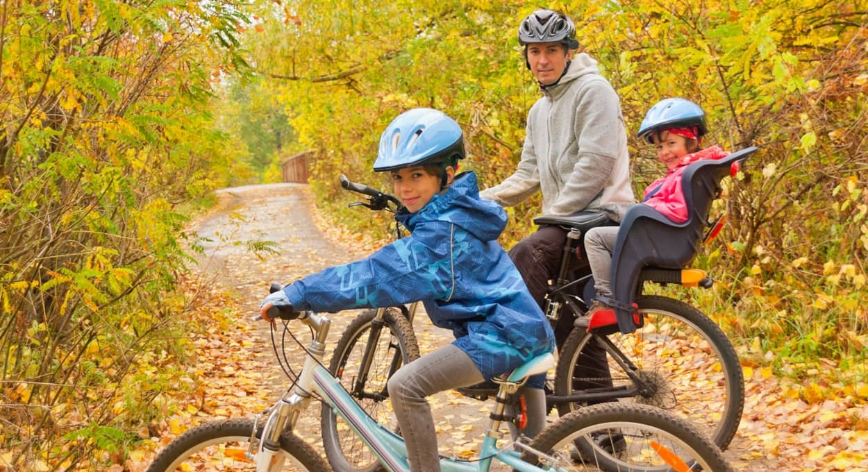 Vater und Kinder im Herbst mit dem Fahrrad unterwegs