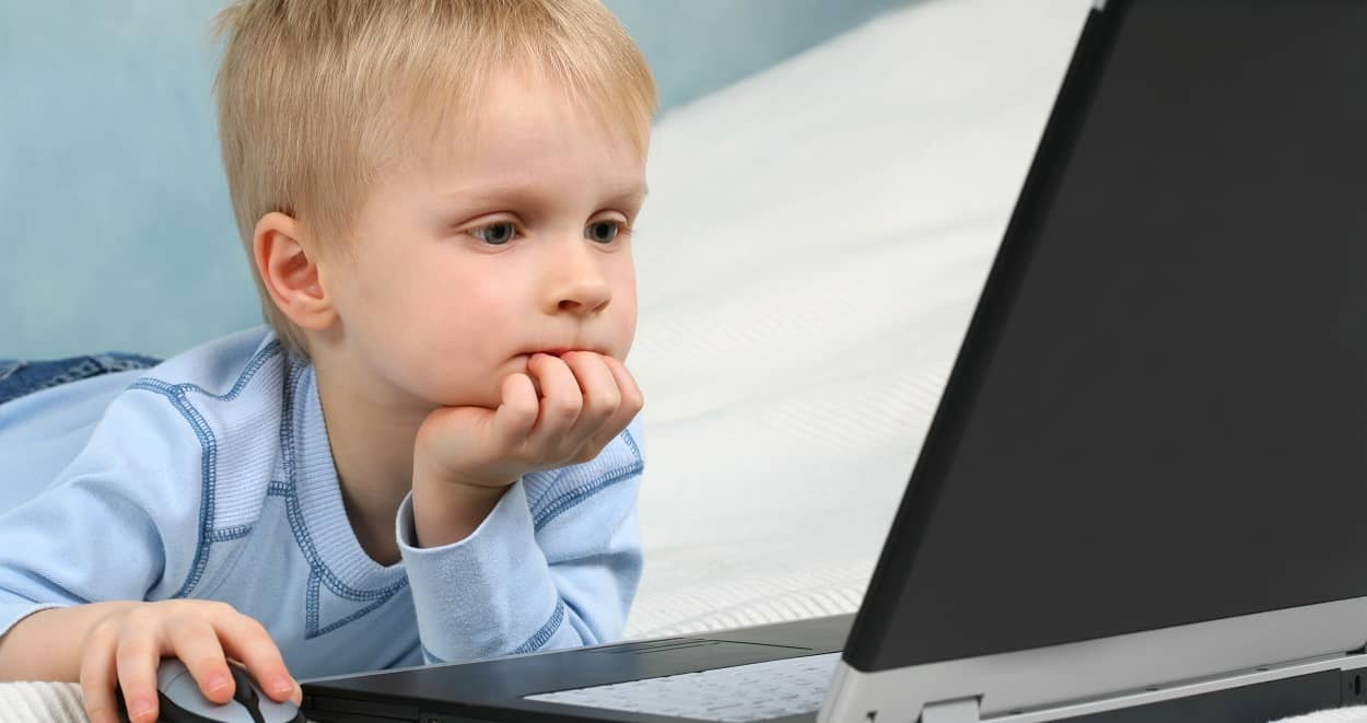 Junge sitzt konzentriert am Computer