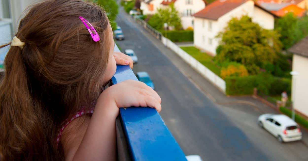 Ein Mädchen schaut vom Balkon