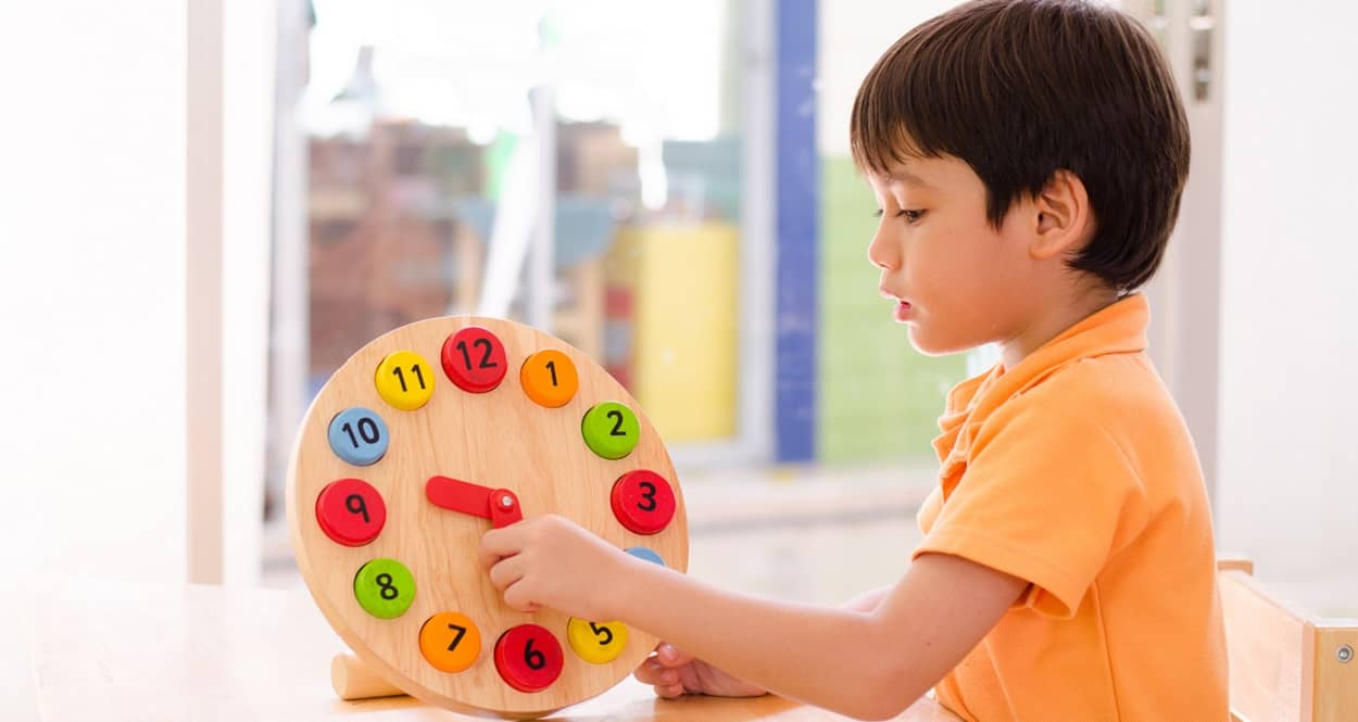 Junge mit einem Spielzeug zum Uhr lesen lernen