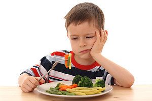 Junge mit einem Teller Gemüse