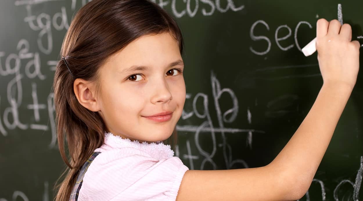 Hochbegabung beim Schulkind erkennen: Mädchen löst Rechenaufgabe an der Tafel