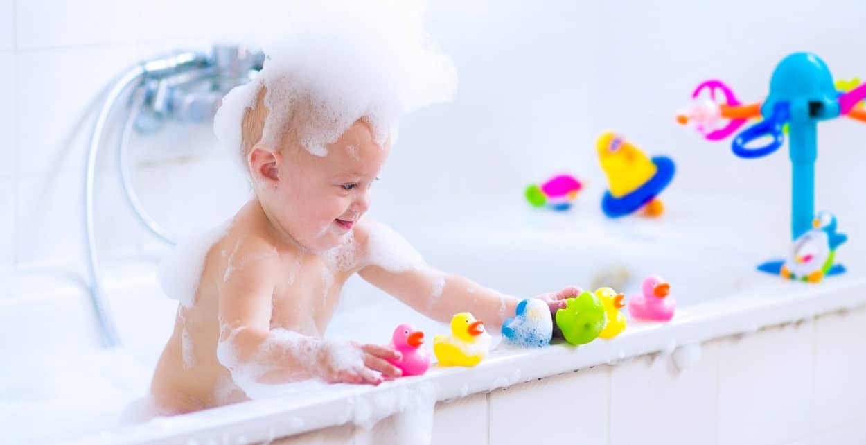 Baby spielt mit Badespielzeug in der Badewanne