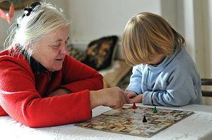 Oma spielt mit ihrem Enkel ein Brettspiel