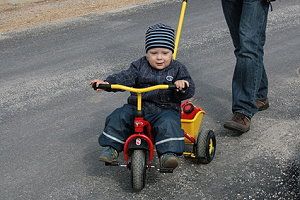 Kleines Kind sitzt auf einem Dreirad
