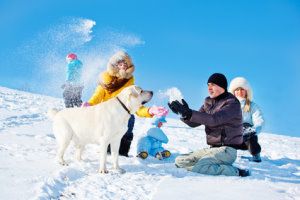 Eltern spielen mit ihren Kindern im Schnee