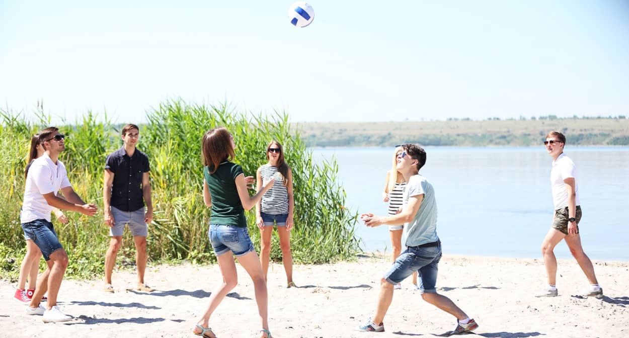 Jugendliche spielen Volleyball am Strand