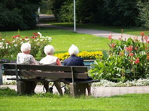 Senioren sitzen auf einer Bank im Park