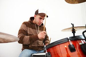 Junger Mann spielt Schlagzeug